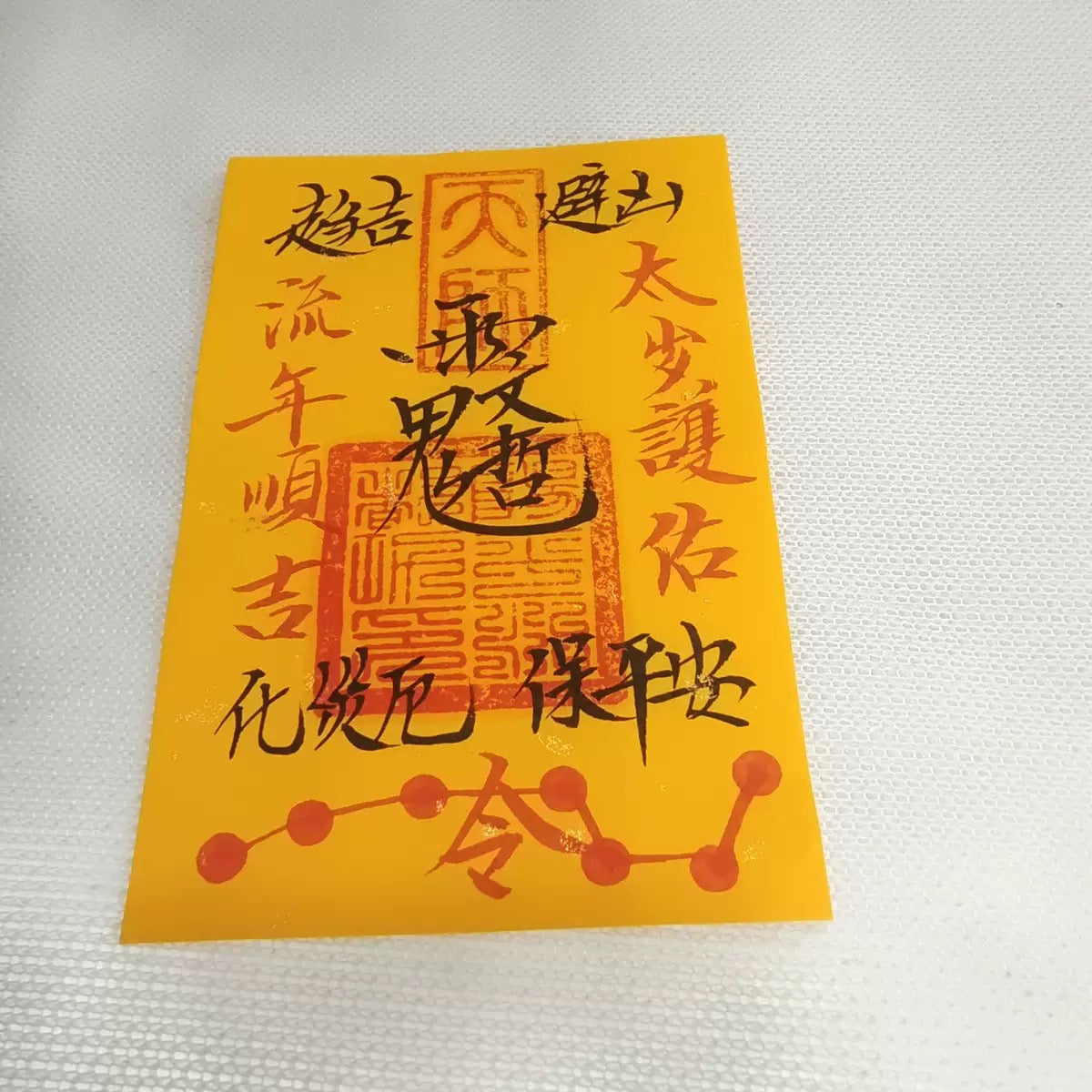 Close-up of traditional Chinese Taoist lucky charm with gold talisman design